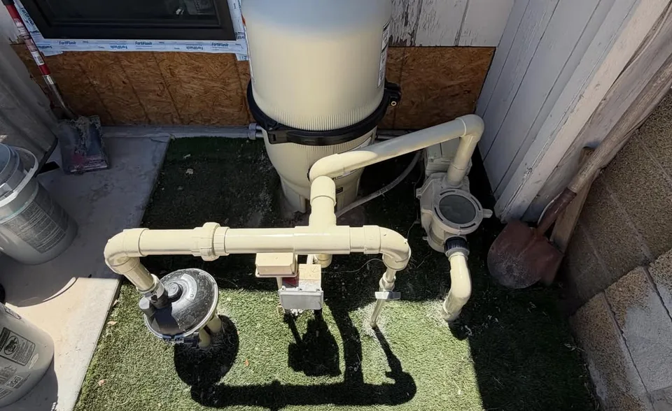 A DE filter and pump plumbing on a pool equipment pad