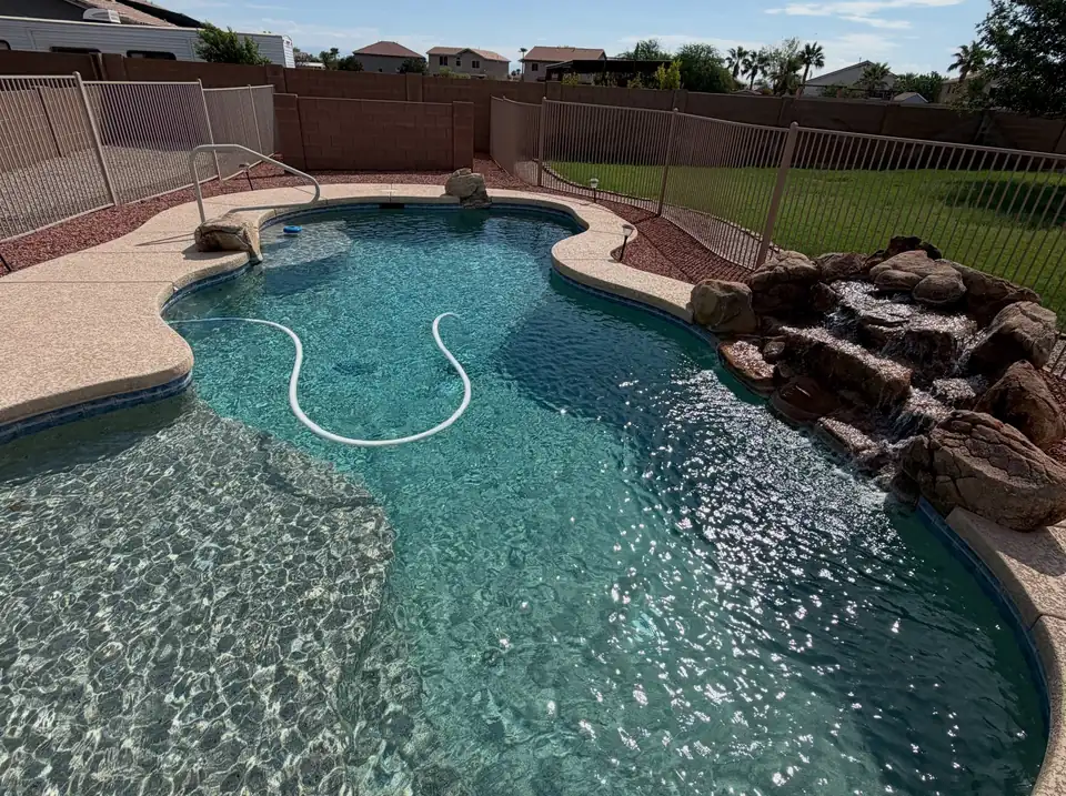 A freeform pool with a rock waterfall and clear water